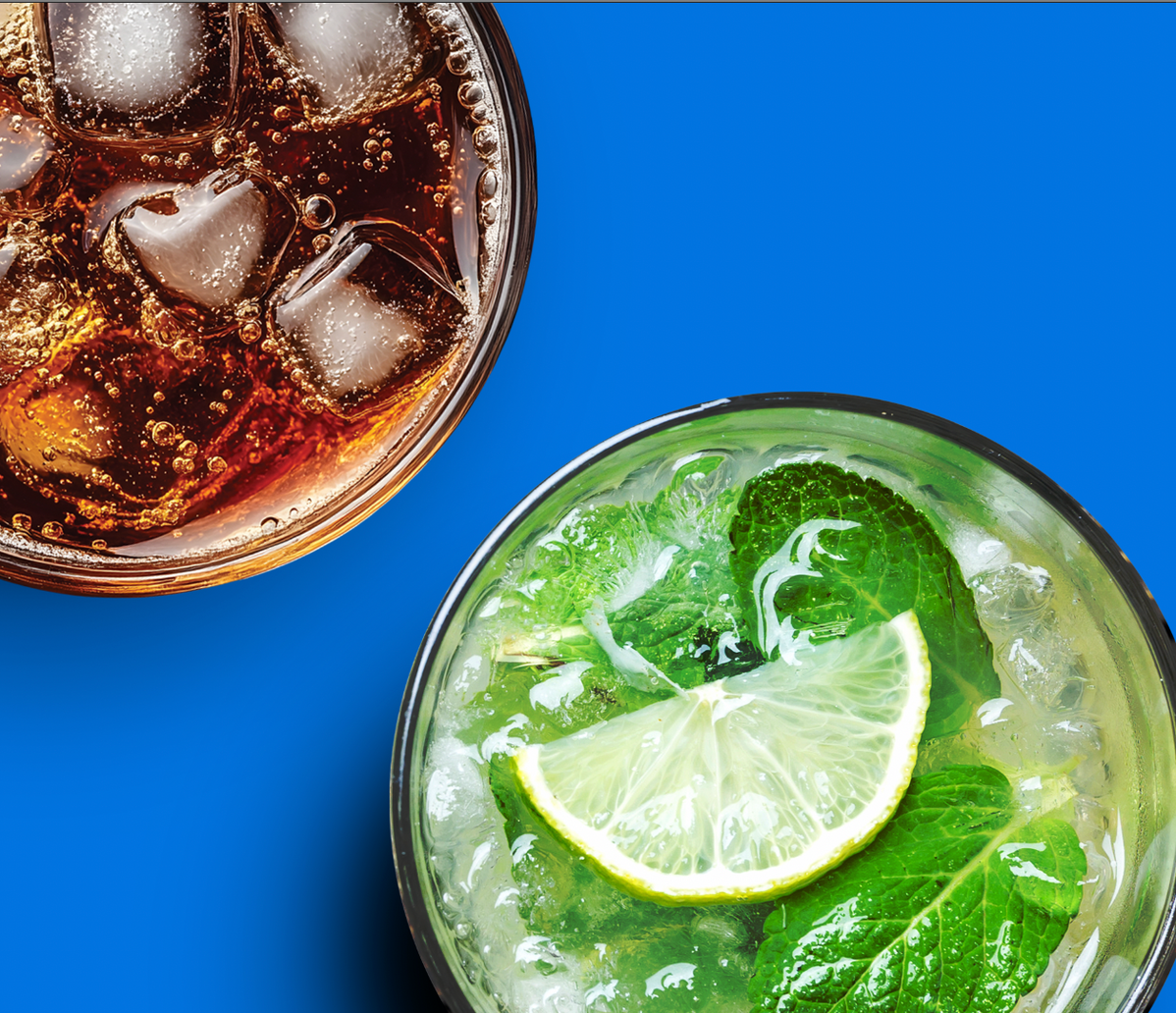 Glass of a sparkling beverage garnished with lime and rosemary.